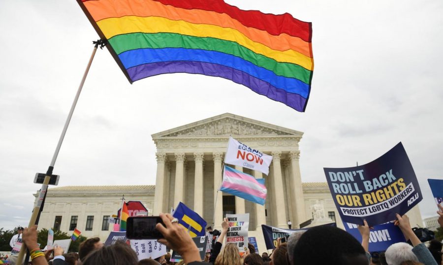 Protesters stand outside of the Supreme Court during the hearing for LGBTQ+ workplace discrimination