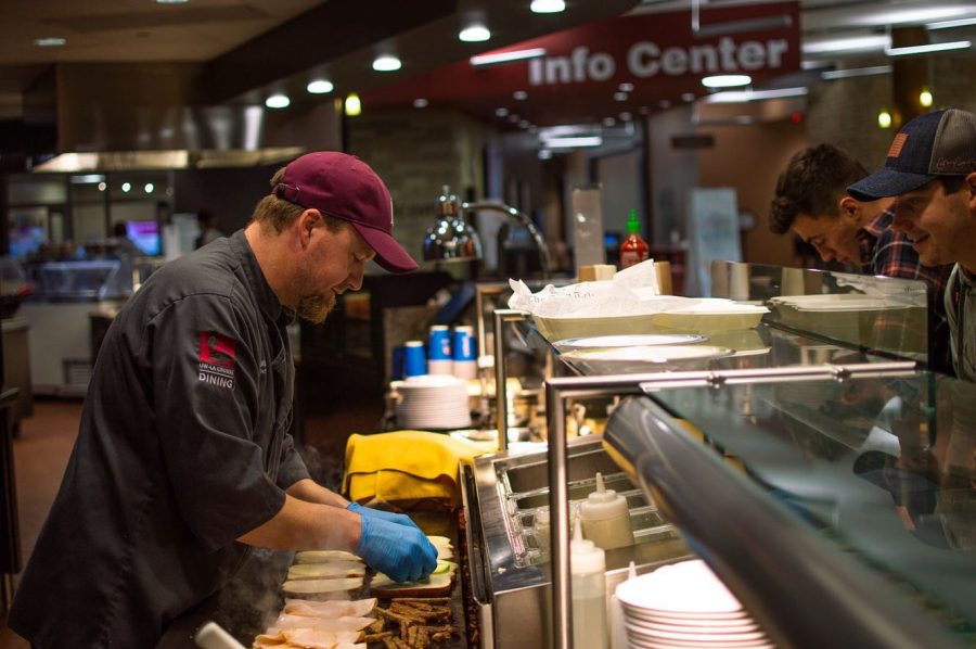 UWL Chef Shawn Miller prepares a sandwich for a waiting student.