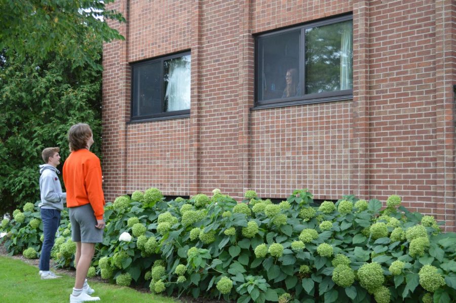 Students talk through a window in Coate Hall. Pictured: Maddy Calarco, Carter Keenan, and Tyler Piek. 