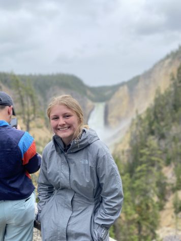 Julia Van Fleet smiling with a view of a waterfall in the background.