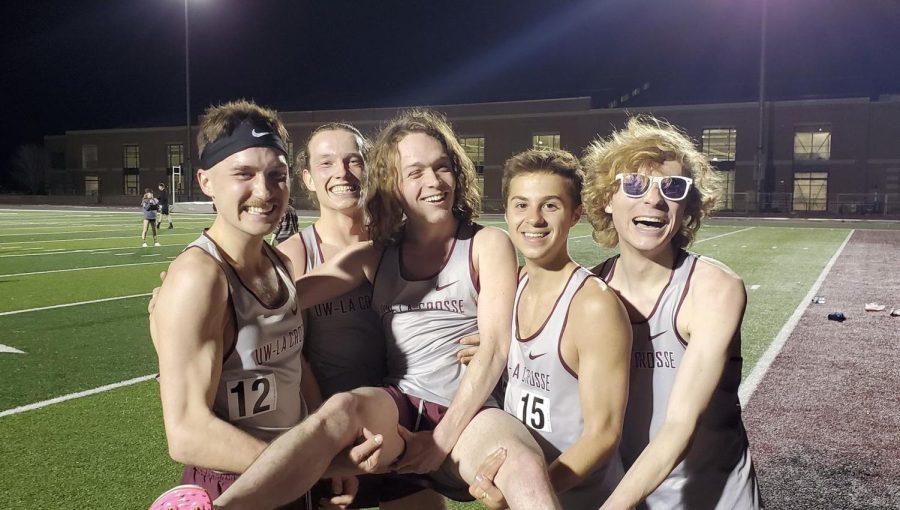 A photograph of five athletes from UWL mens track and field team smiling. Four of the men are holding up Ethan Gregg.