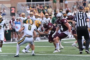 Gabe Lynch attempts to break a tackle. Photo taken by Jim Lund. 