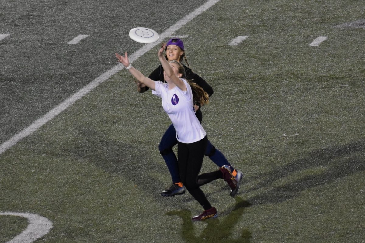 Maddie Schneider catching a deep pass while Jessica Barrett looks on. Photo by Paige Geiser. 