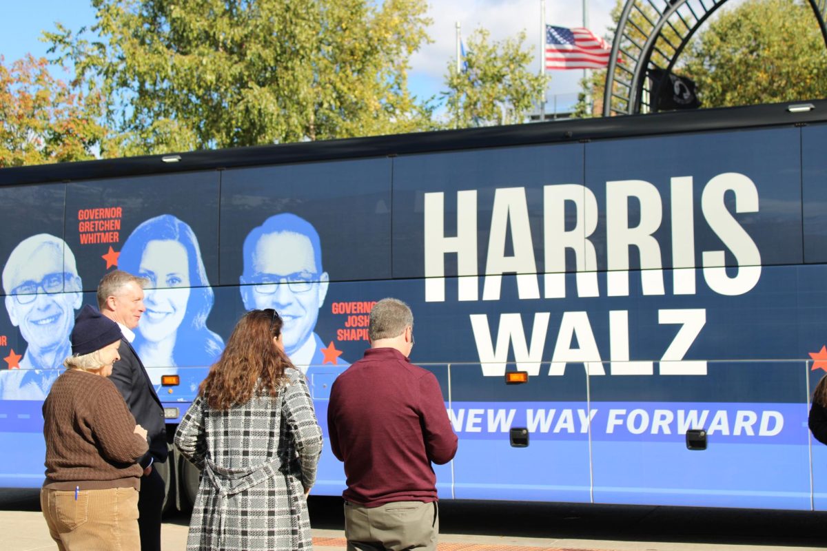 La Crosse Mayor Mitch Reynolds, Tara Johnson, Jill Billings and Brad Pfaff watch the arrival of the Blue Wall Bus. 