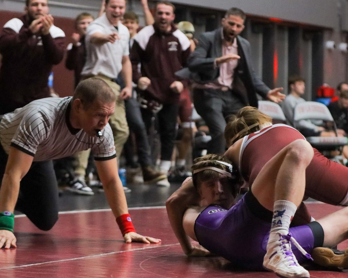 UWL Wrestler puts their opponent to their back looking for the fall