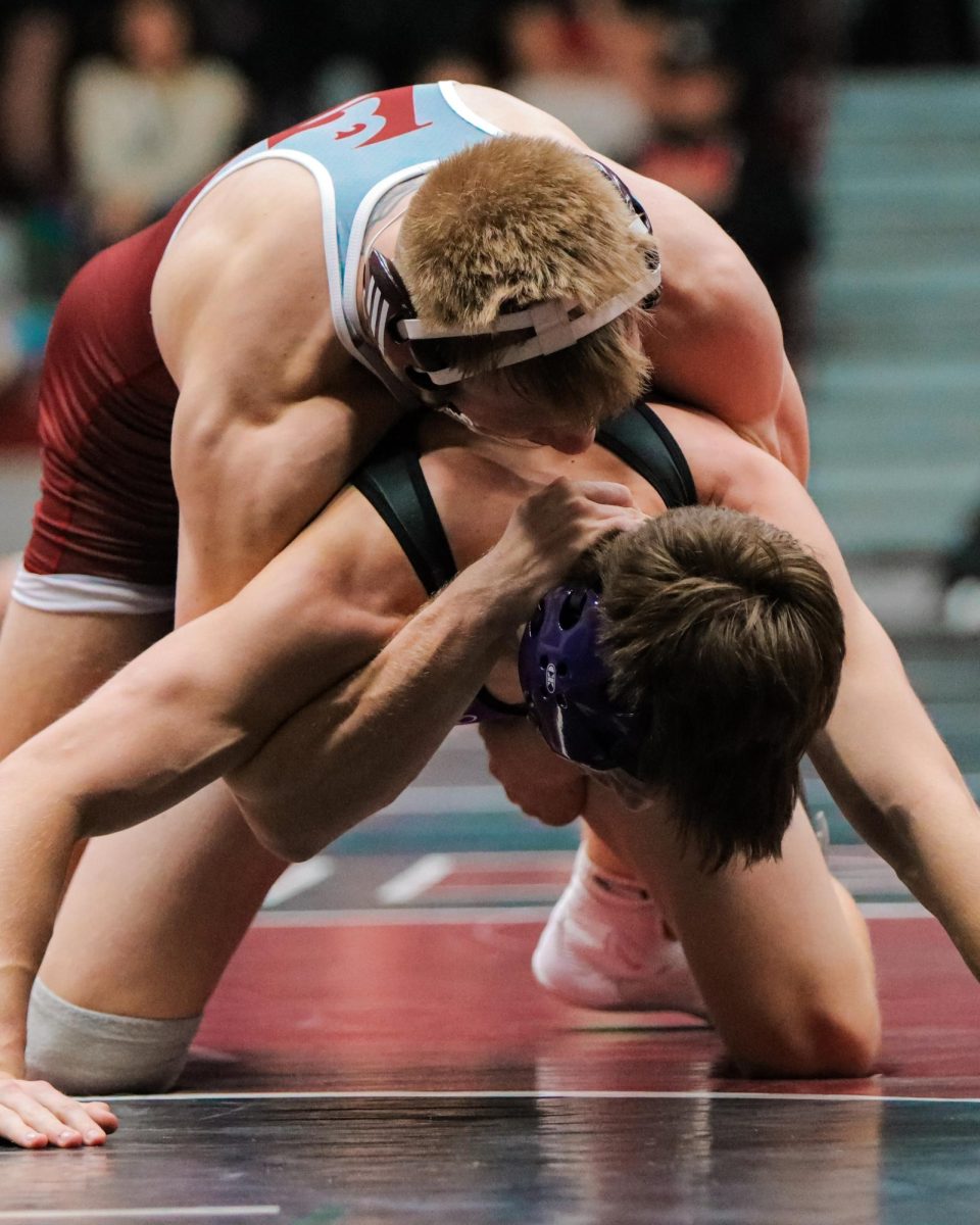 UWL Wrestler puts opponent in a half-nelson.