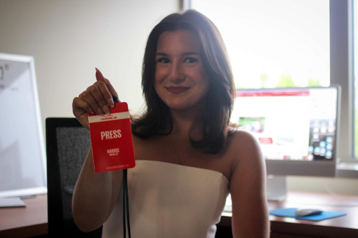 Isabel Piarulli holding press pass for Harris rally in The Racquet Press offices. Photo by Trinity Rietmann.
