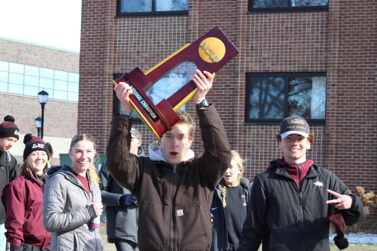 Cross country team brandishing championship trophy. Photo by Colin Cronan. 