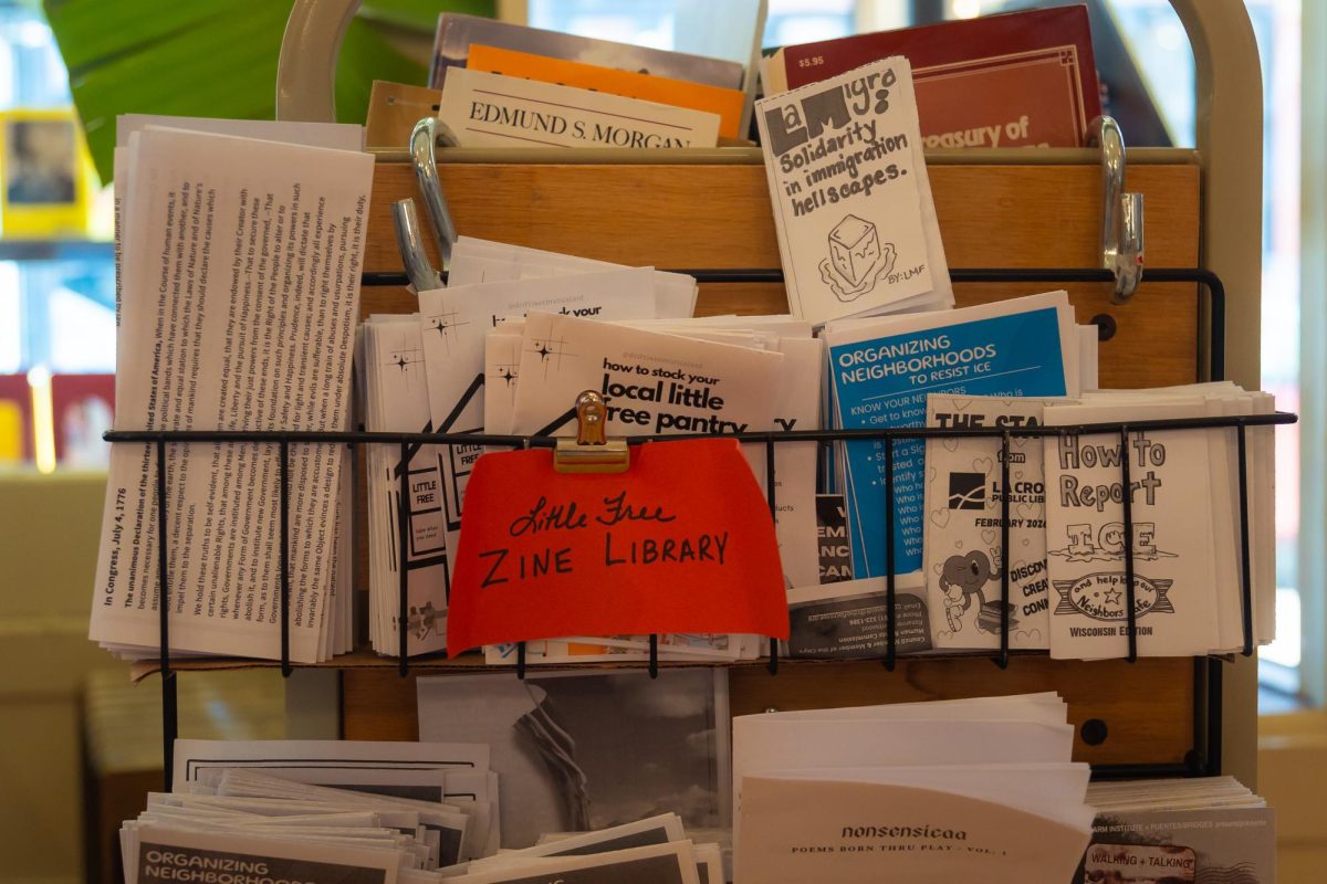 Pamphlets and zines with community resources displayed in a rack at Pearl Street Books in La Crosse. Photo by Sam Hall.